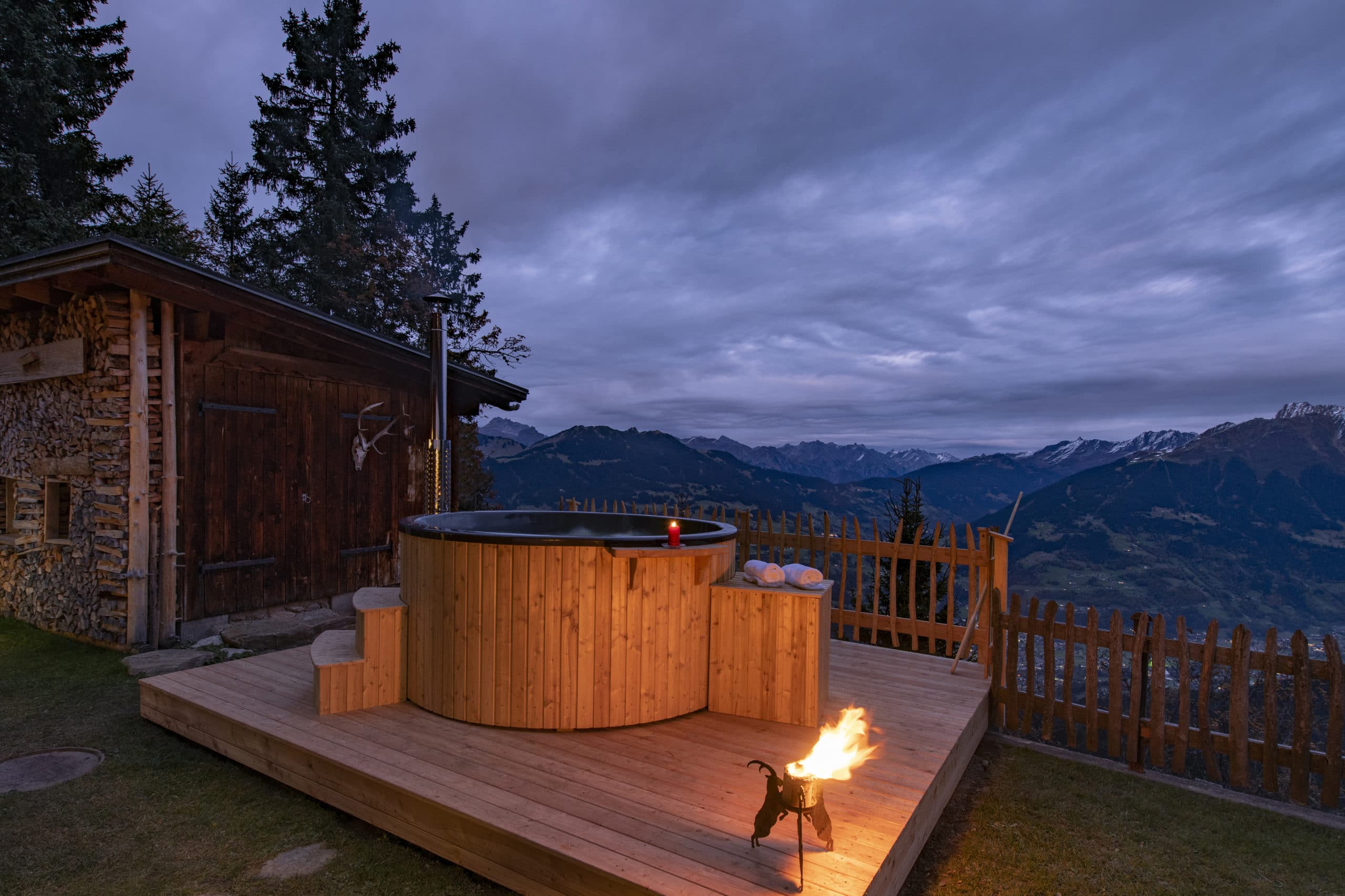 Holz-Whirlpool mit Bergblick bei Dämmerung